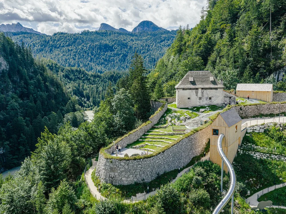 Fort Kniepass in the Saalachtal, Salzburg State, Austria — the 14th-century border fortification at the Kniepass bend in the valley, with wooded Alpine hillsides and the Saalach river valley below