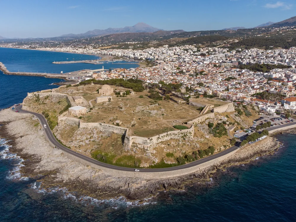 Fortezza of Rethymno on the Palaiokastro promontory above Rethymno old town, Crete, Greece — one of the largest Venetian fortresses ever built, with the Ibrahim Han mosque dome visible above the massive limestone bastions