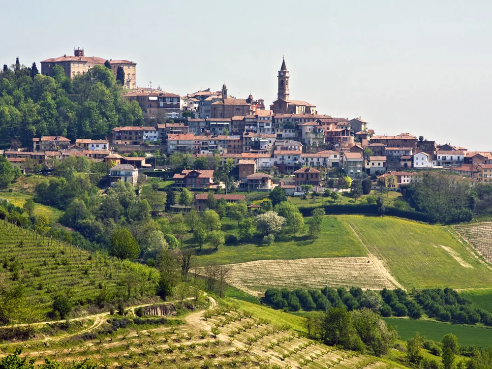 Govone Castle (Castello di Govone) on its hilltop in the Roero hills, Cuneo province, Piedmont, Italy — the UNESCO-inscribed Savoy royal summer residence above the Langhe wine country