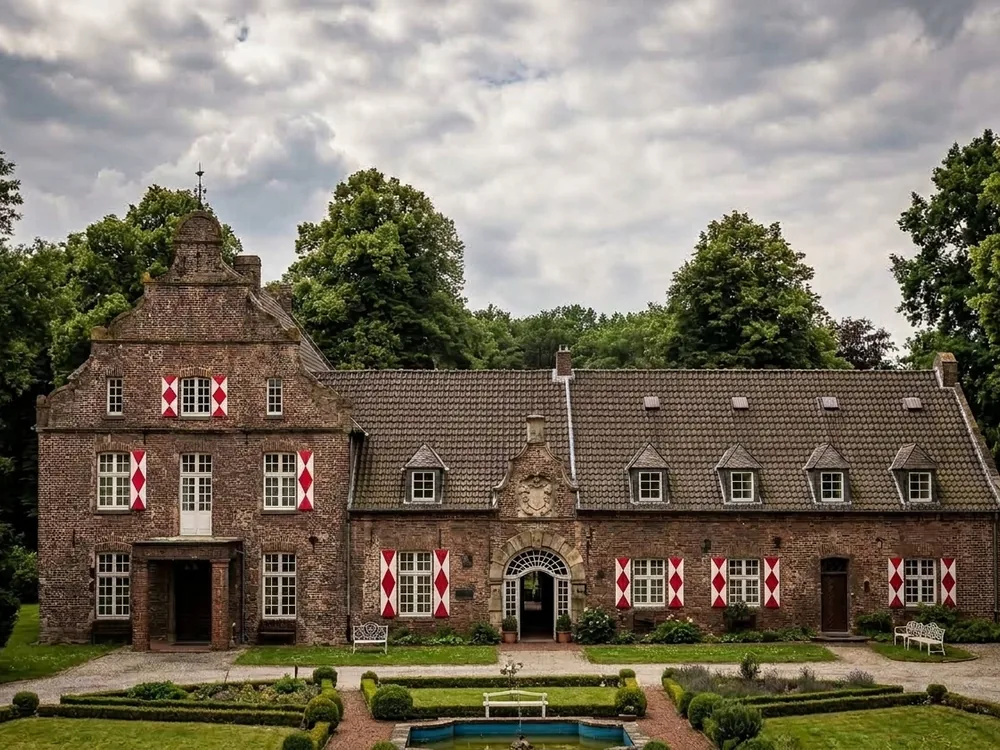Hertefeld Castle on the River Niers near Weeze, North Rhine-Westphalia, Germany, rebuilt from its 1945 ruins