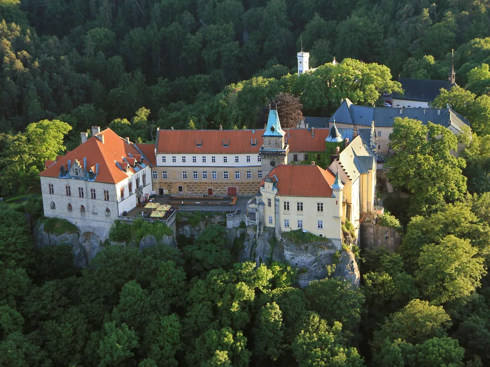 Hrubá Skála Château (Zámek Hrubá Skála) perched on the edge of the Hruboskalsko sandstone rock formations in the Bohemian Paradise, Czech Republic — the baroque château emerging from the Cretaceous sandstone above the forested rock city