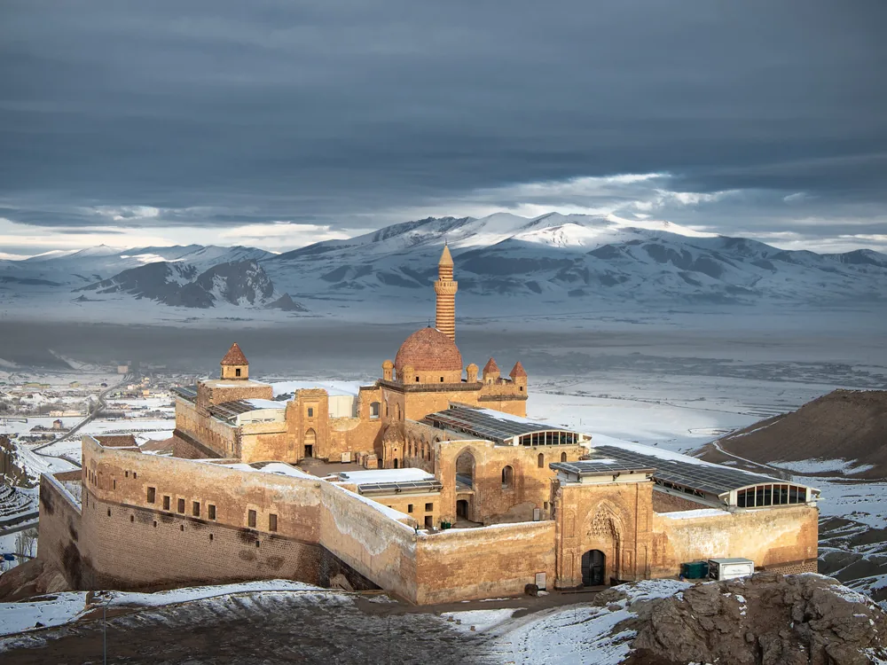 Ishak Pasha Palace (İshak Paşa Sarayı) on the cliff above Doğubayazıt in eastern Turkey, with Mount Ararat visible in the background — the 1685–1784 Ottoman palace in Ağrı Province, Turkey