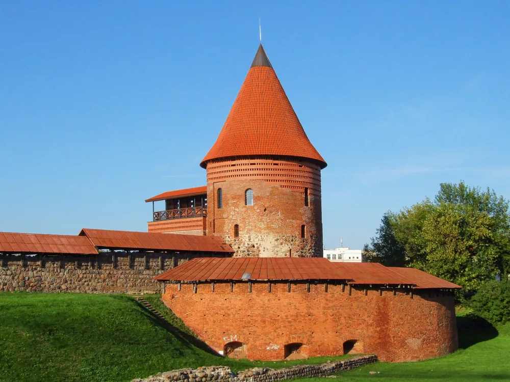 Kaunas Castle — the 14th-century Gothic brick fortress at the confluence of the Nemunas and Neris rivers in Kaunas, Lithuania, showing the surviving western tower and curtain wall