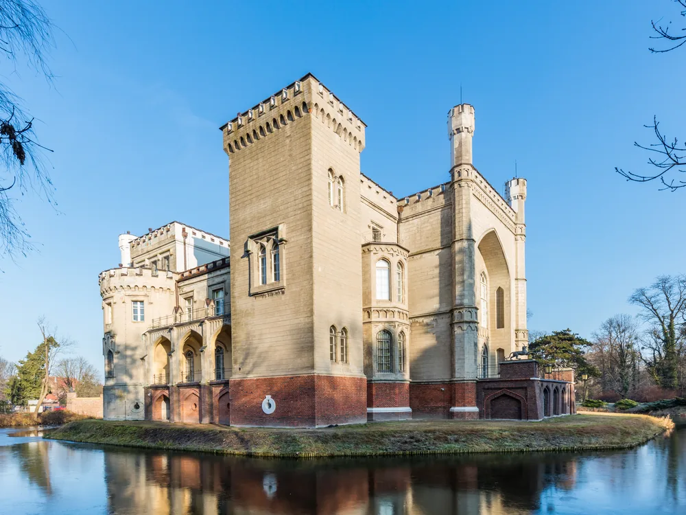 Kórnik Castle (Zamek Kórnik) reflected in the lake, Greater Poland — Karl Friedrich Schinkel's neo-Gothic masterpiece with crenellated battlements and turrets, the Działyński family's castle of Polish national culture