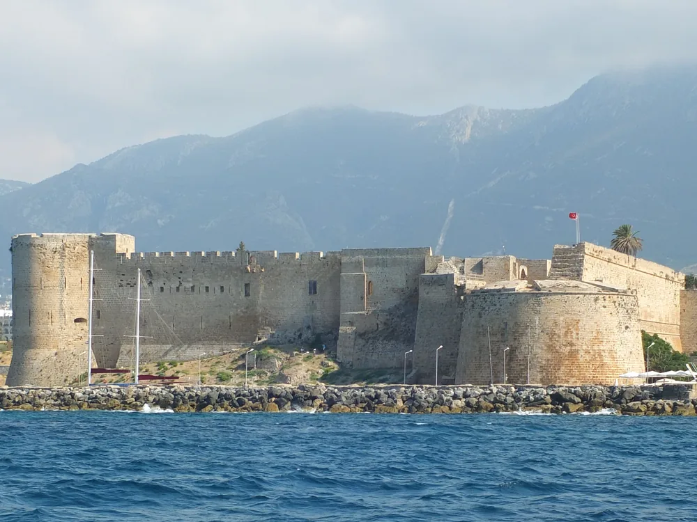 Kyrenia Castle (Girne Kalesi) — the Venetian-era harbour fortress enclosing the horseshoe harbour of Kyrenia (Girne) in Northern Cyprus, with the Kyrenia Mountains rising behind the town