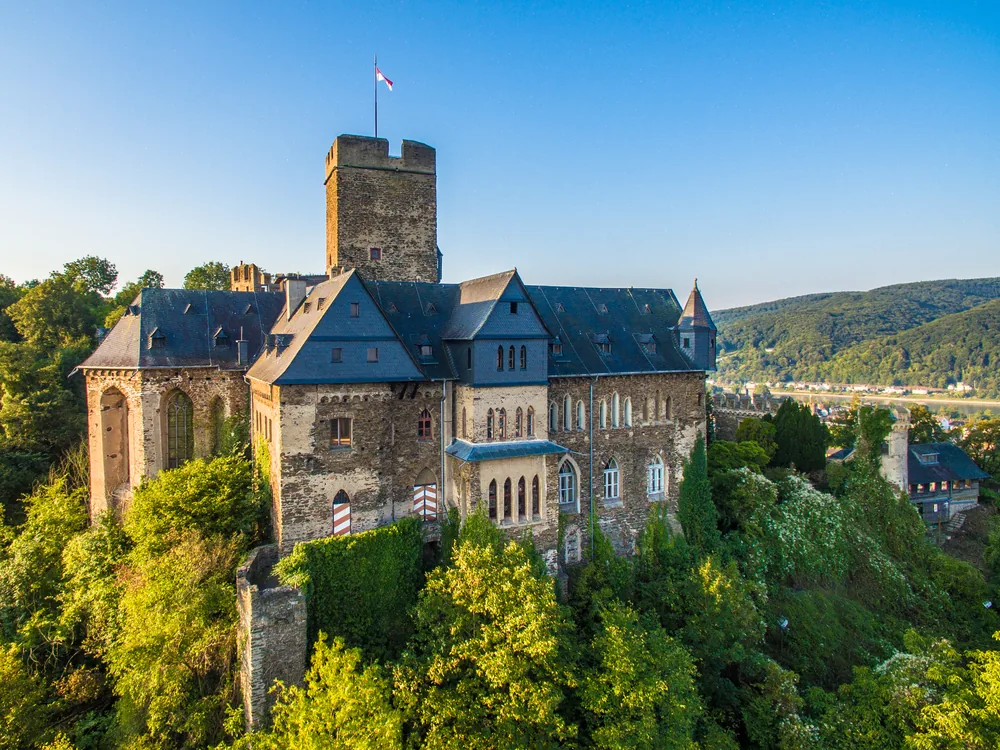 Lahneck Castle (Burg Lahneck) on its bluff above the Lahn-Rhine confluence at Lahnstein — the 1226 Archbishop of Mainz fortress rebuilt in Neo-Gothic style 1864–1908, still a private family residence