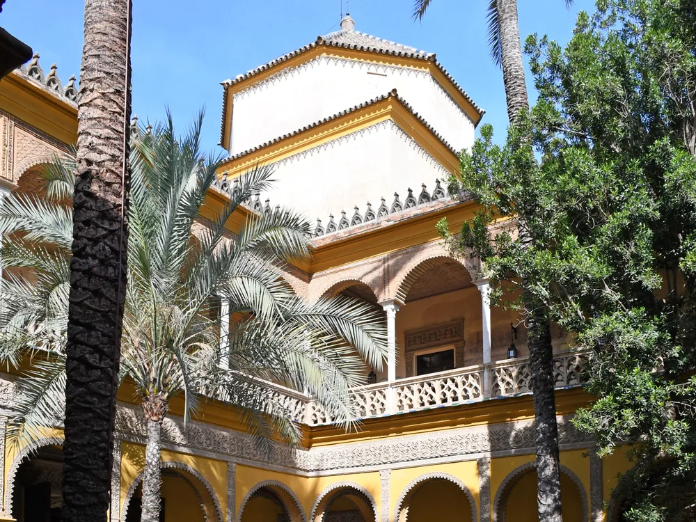Las Dueñas Palace main patio — the arcaded Ionic courtyard of Seville's Ducal palace with Mudéjar tiles and garden, still inhabited by the House of Alba