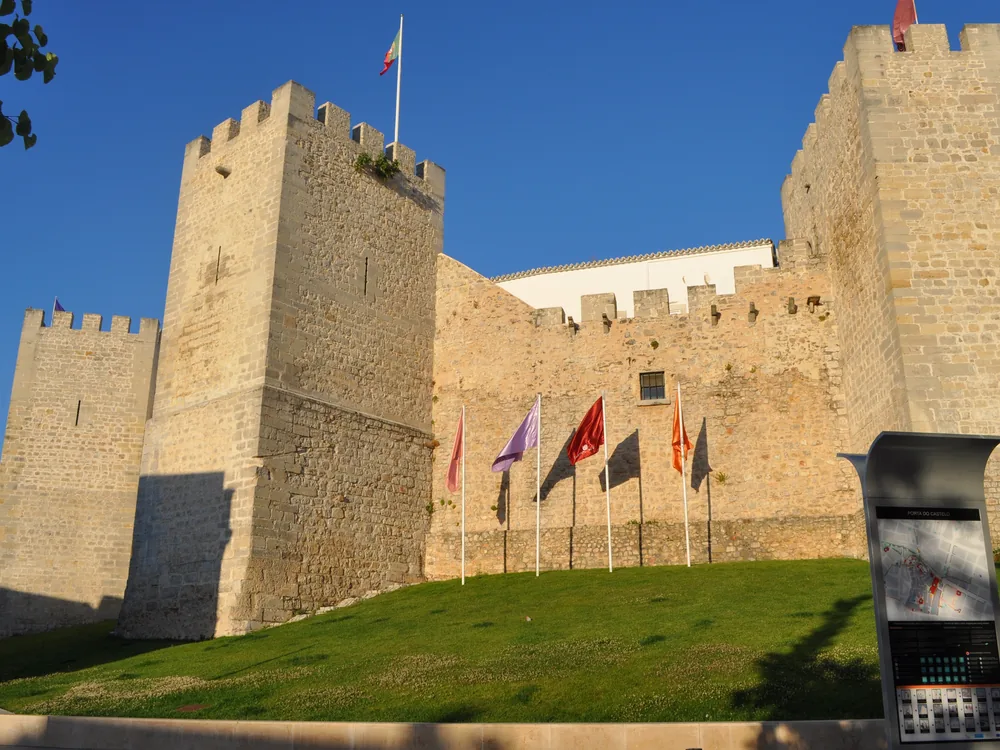 Loulé Castle (Castelo de Loulé) — the Islamic-era tower and medieval walls in the inland Algarve, Barrocal zone, with the neo-Moorish Municipal Market visible in the town below, Faro District, Portugal