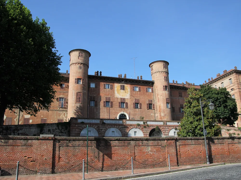 Moncalieri Castle on its hilltop south of Turin — the 13th-century fortification transformed into a Baroque Savoy royal residence, now an active Carabinieri base with periodic guided visits to the normally-closed royal apartments