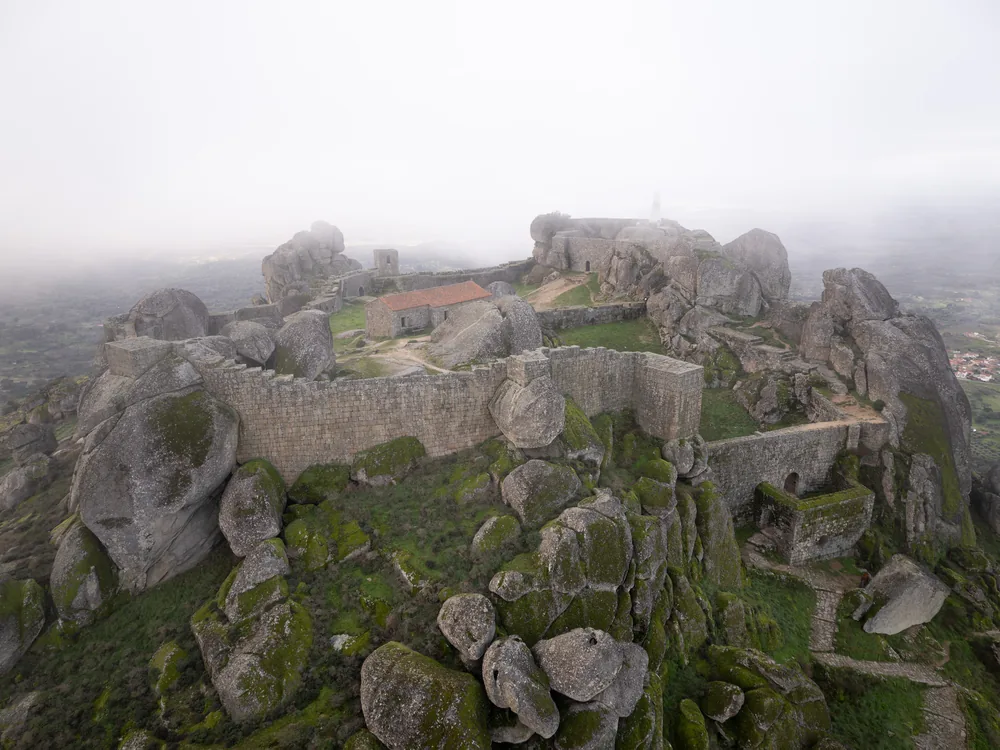 Castle of Monsanto (Castelo de Monsanto) above the granite boulder village of Monsanto, Beira Baixa, Portugal — the medieval castle integrated with massive granite formations, with panoramic views over the Castelo Branco plains