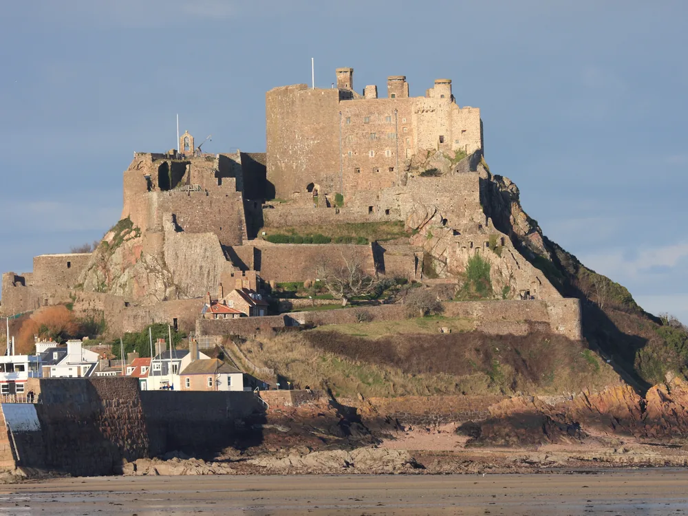 Mont Orgueil Castle (Château Mont-Orgueil) rising from the granite headland above Gorey Harbour on Jersey's east coast — 13th-century medieval concentric fortification with WWII German Occupation layers, Jersey, Channel Islands