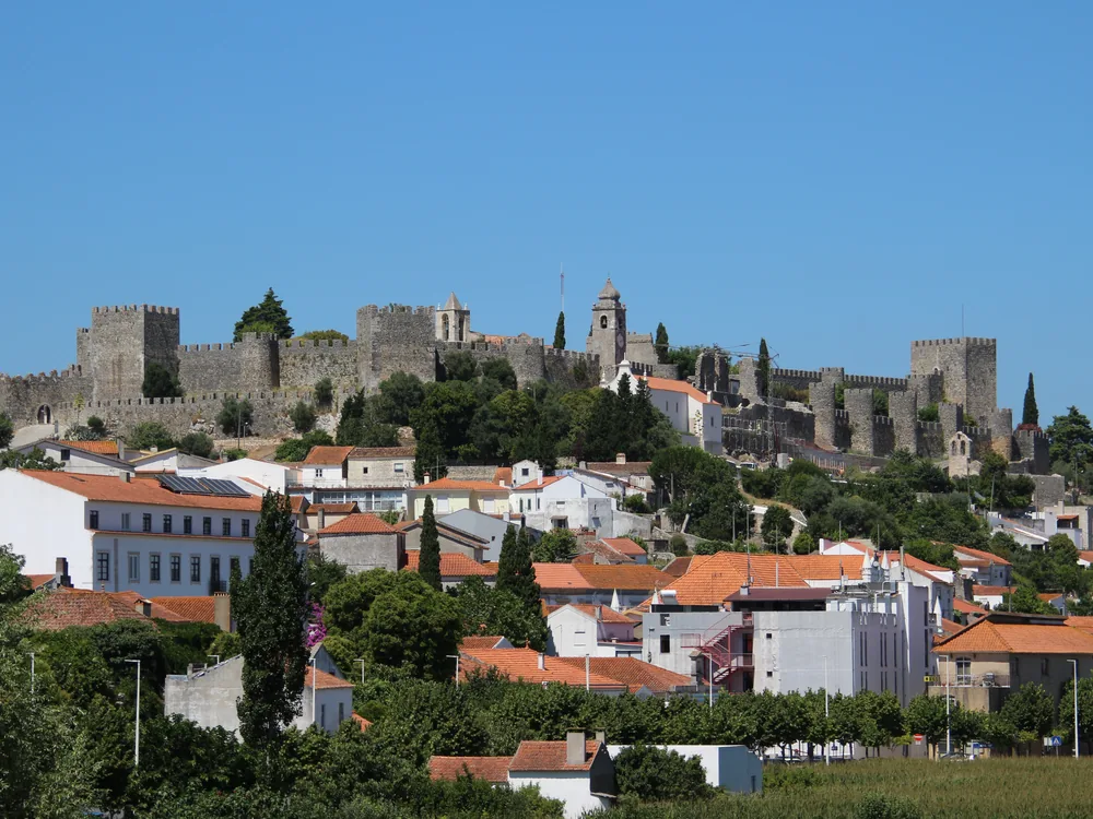 Castle of Montemor-o-Velho (Castelo de Montemor-o-Velho) on its ridge above the Mondego River plain, Coimbra District, Portugal — the elongated medieval Reconquista fortress with the Romanesque church of Santa Maria de Alcáçova