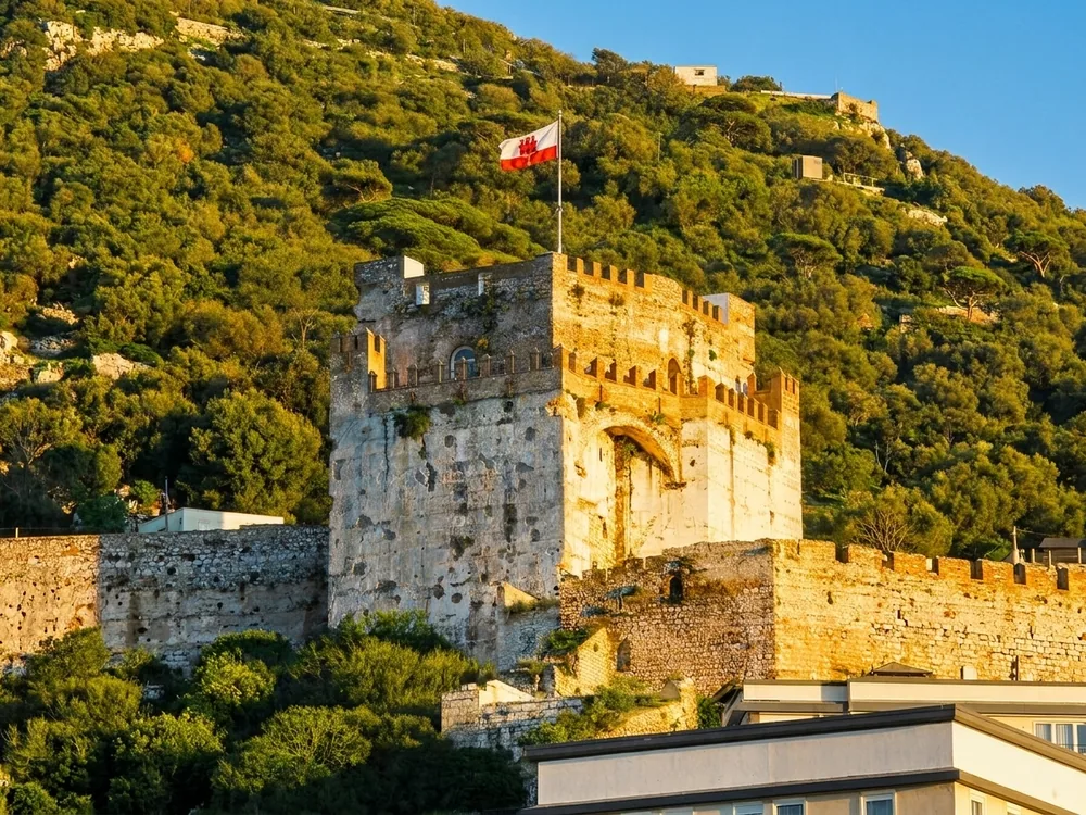 The Moorish Castle Tower of Homage on the Rock of Gibraltar — the 14th-century Marinid fortress tower with distinctive alternating red and buff brickwork, the oldest named landmark in the western Mediterranean