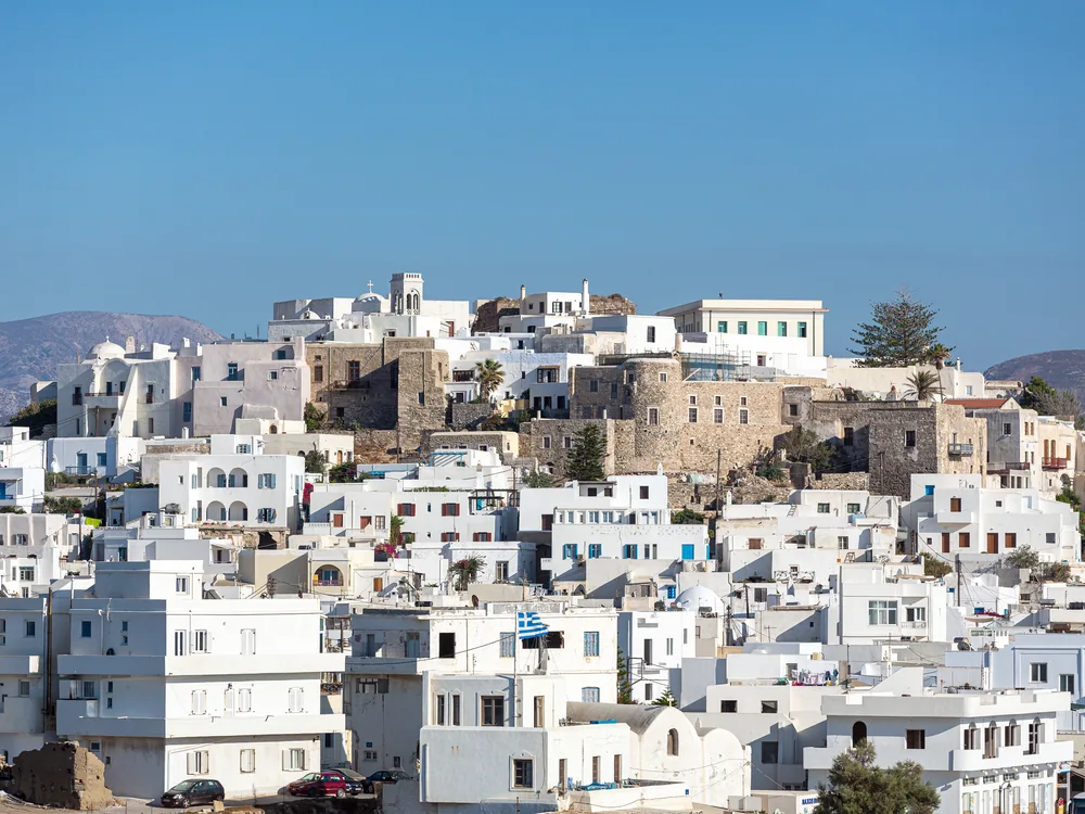 The Venetian kastro of Naxos above Naxos Town (Chora), Cyclades — the 13th-century fortified hilltop neighbourhood founded by Marco Sanudo in 1207, with the Portara visible on the causeway below