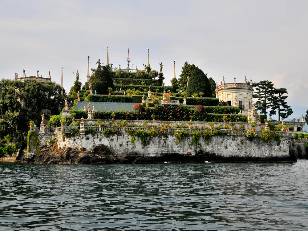 Palazzo Borromeo on Isola Bella seen from Lake Maggiore — the Baroque palace and terraced gardens rising from the water with the Alps behind