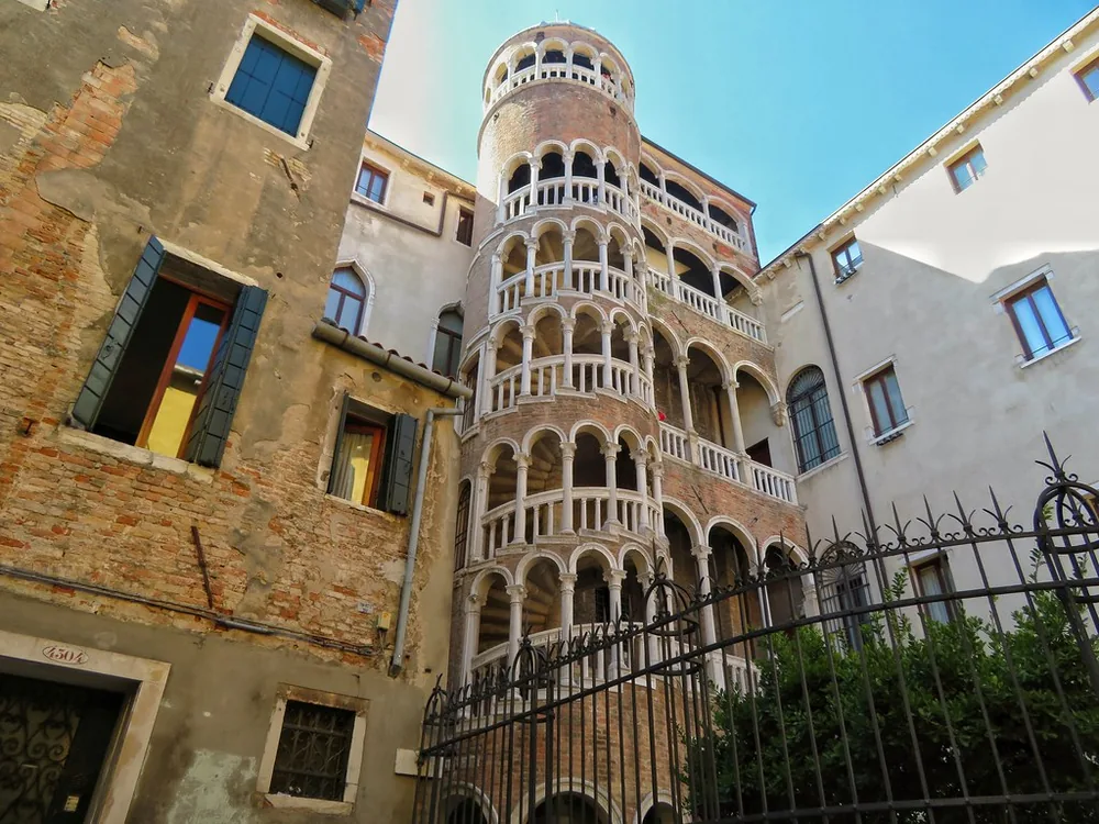 Palazzo Contarini del Bovolo in Venice — the extraordinary external spiral staircase with five loggia levels blending Gothic pointed arches and Renaissance roundels, rising above a hidden courtyard in the San Marco sestiere