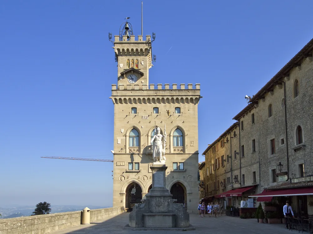 Palazzo Pubblico on Piazza della Libertà in San Marino City — the 1884–1894 neo-Gothic seat of the Captains Regent and the Grand and General Council, the government palace of the world's oldest surviving republic, with the Statue of Liberty in the foreground