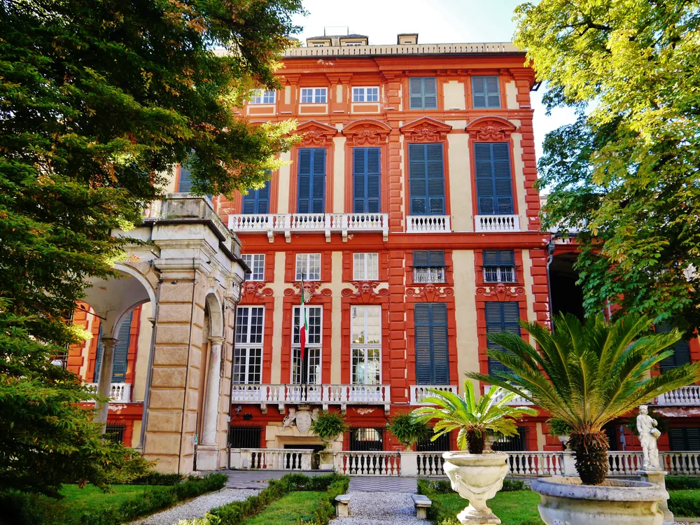 Palazzo Rosso on Via Garibaldi, Genoa — the red-ochre Baroque facade of the 1671–1677 Brignole Sale palace, now a public art museum with Van Dyck portraits and Old Master paintings
