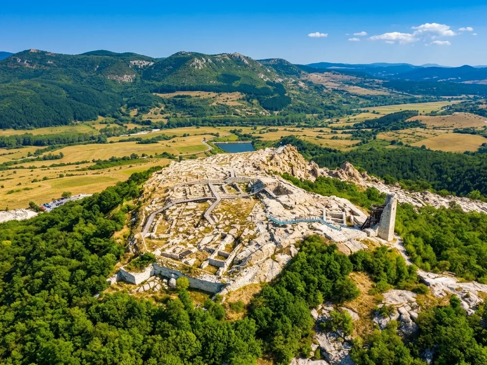 Perperikon megalithic rock complex in the Eastern Rhodopes, Bulgaria — the ancient Thracian sanctuary city carved entirely from trachyte bedrock, with rock-cut palace rooms, altars, and cisterns on a hilltop above the river valley