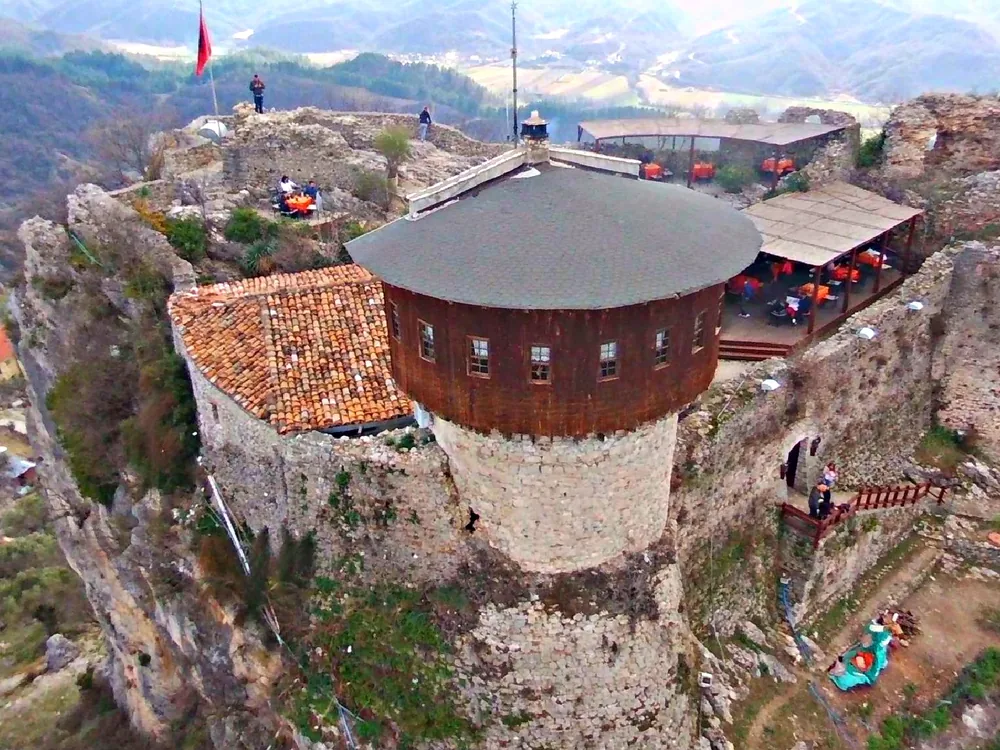 Petrela Castle (Kalaja e Petrelës) on its rocky hilltop above the Erzen river valley, 22 km southeast of Tirana, Albania — the Byzantine-era fortress associated with Skanderbeg