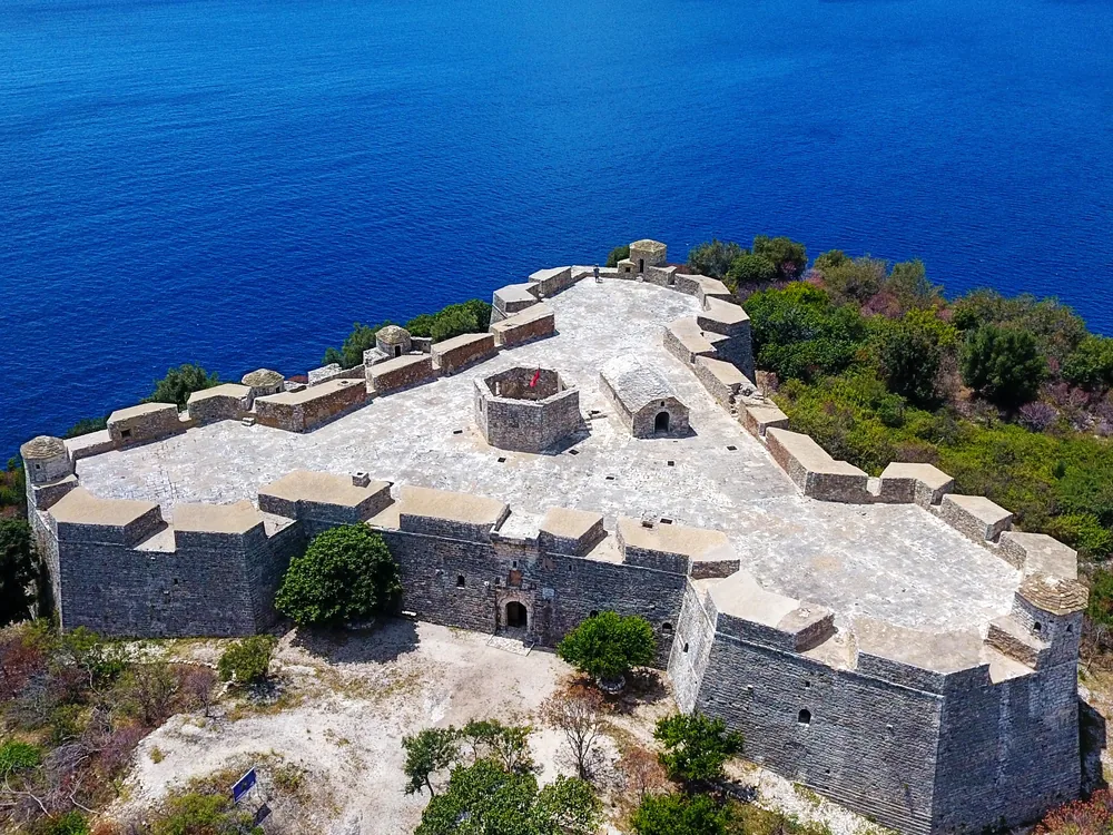 Porto Palermo Castle on its rocky peninsula above the Albanian Riviera — the triangular Ottoman fortress built by Ali Pasha of Ioannina above the sheltered Ionian harbour