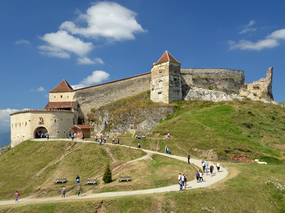 Râșnov Fortress on its hilltop above the Bârsa plain in Transylvania, with the Bucegi Mountains in the distance