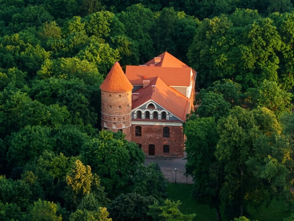 Raudondvaris Manor — the Gothic Revival red-brick manor house on the Nevėžis River, Kaunas District, Lithuania, rebuilt 1832–1855 by Count Tyszkiewicz on the site of the Teutonic Order's Königsburg and Queen Barbara Radziwiłł's Renaissance manor