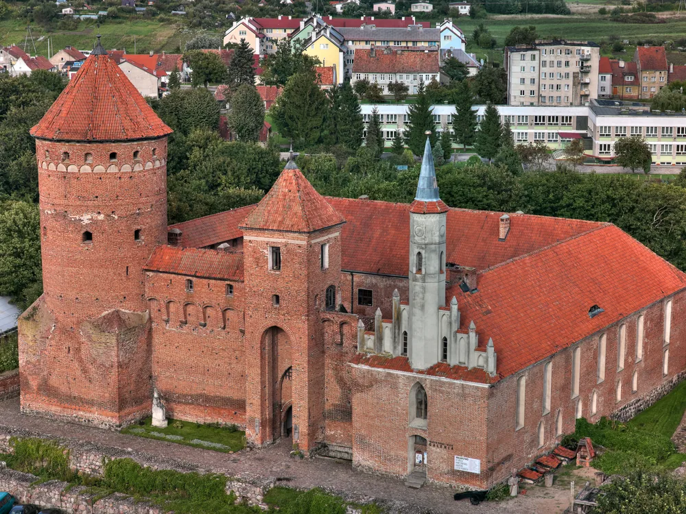 Reszel Castle on the Sajna river in Warmia, Poland — a Brick Gothic fortress built 1350–1401, now a museum, hotel and restaurant