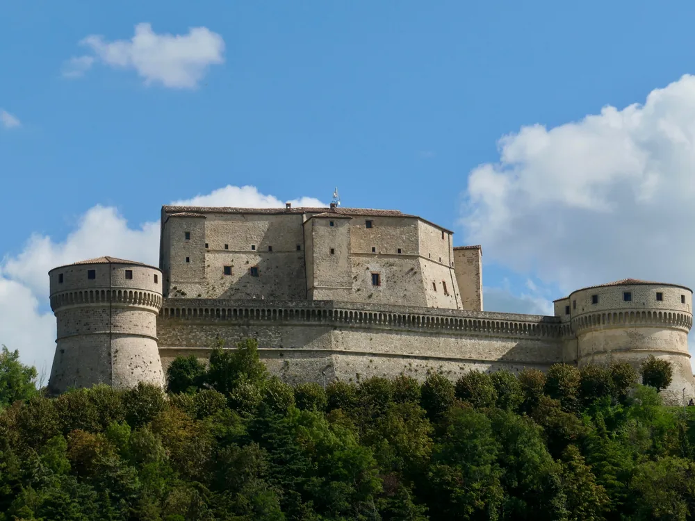 San Leo Fortress on its sheer sandstone pinnacle in the Montefeltro, Italy — Francesco di Giorgio Martini's 1479 Renaissance military fortress above the Valmarecchia valley, where the Count of Cagliostro died in prison in 1795