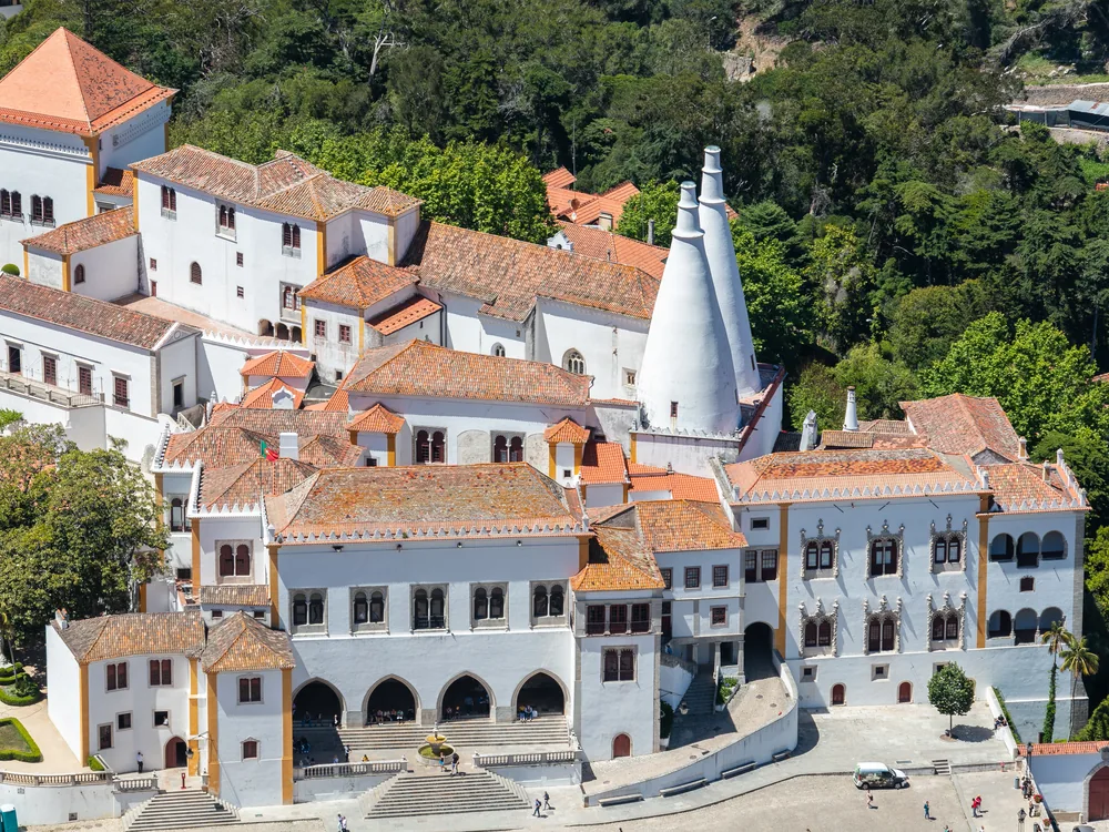The Sintra National Palace with its distinctive twin conical chimneys rising above the medieval town centre — the best-preserved royal palace in Portugal, in continuous use from Dom João I to the late 19th century