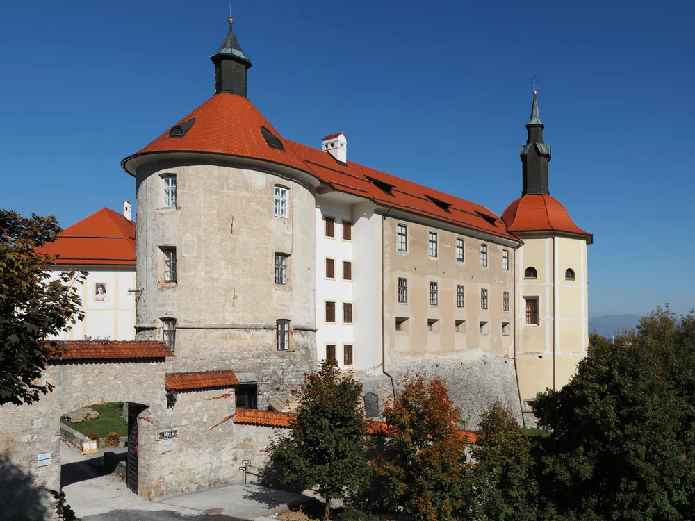 Škofja Loka Castle on its wooded hill above the medieval old town of Škofja Loka in Upper Carniola, Slovenia — the 12th-century seat of the Bishops of Freising, housing the Loka Museum