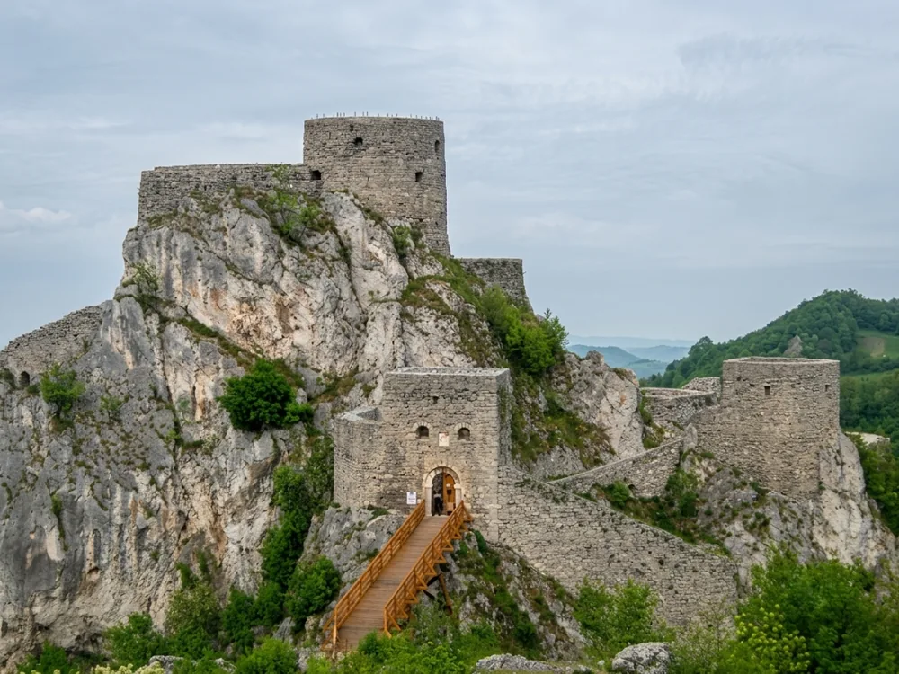 Srebrenik Fortress — the medieval clifftop citadel in Tuzla Canton, Bosnia, rising 70 metres above the surrounding terrain on three sheer cliff faces, with the stone bridge the only approach