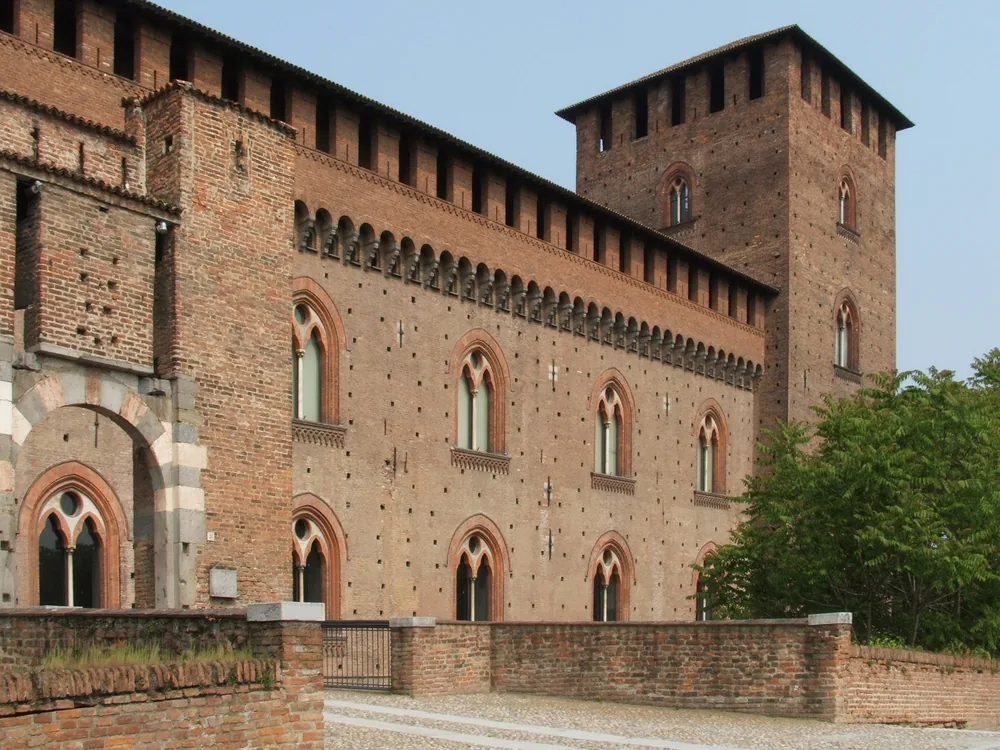 The red-brick Castello Visconteo di Pavia with its surviving corner towers and arcaded courtyard, the great 14th-century Visconti fortress on the banks of the Ticino River