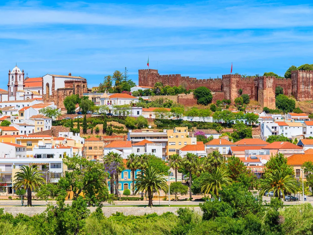 Silves Castle red sandstone walls above the orange groves of the Algarve, Portugal