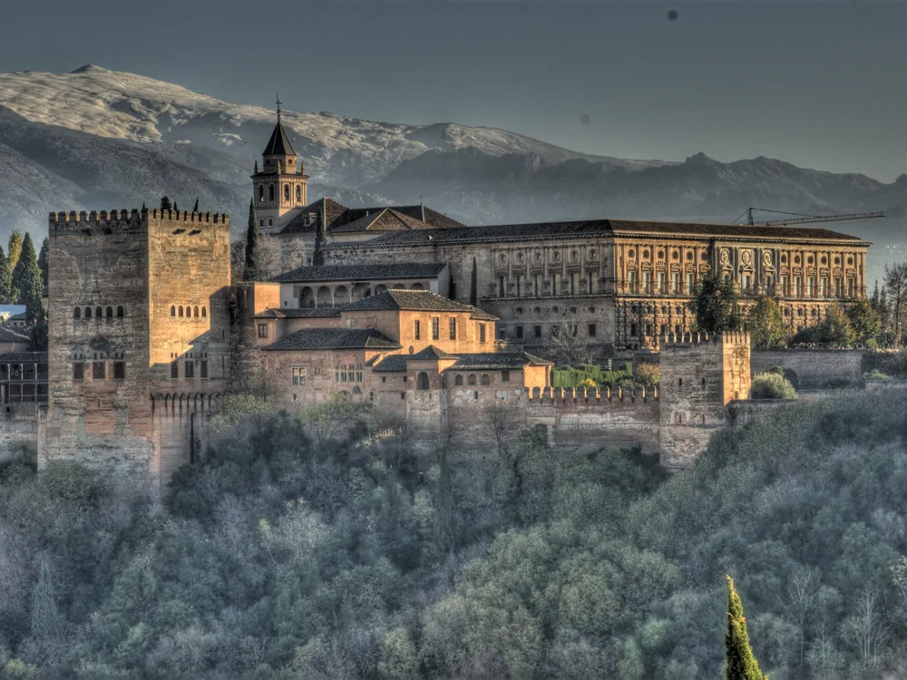 The Alhambra palace complex rising above Granada with the Sierra Nevada behind