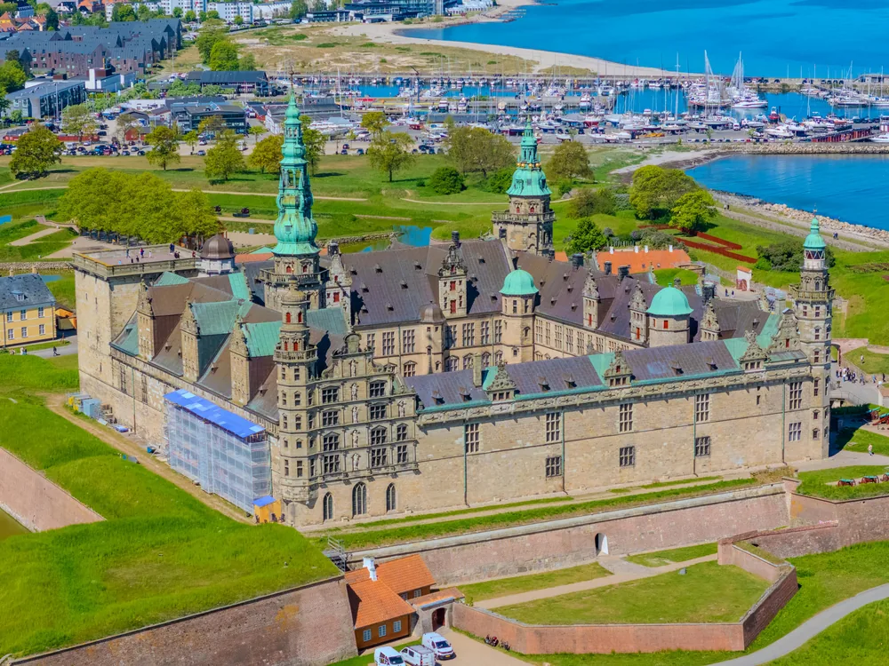 Kronborg Castle rising above the Øresund strait at dawn, Sweden visible on the far shore