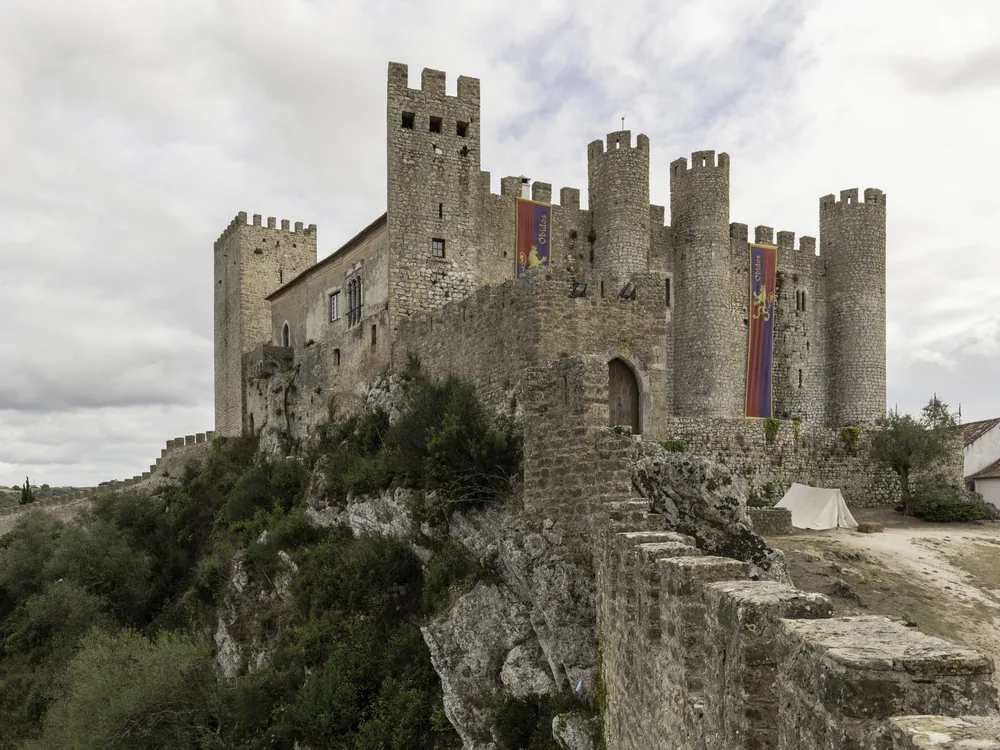 The white walls and castle of Óbidos village rising above the Portuguese countryside