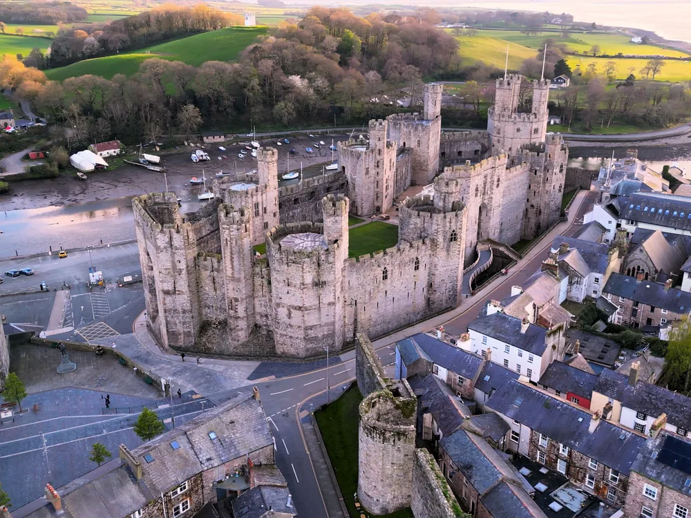 Conwy Castle and the medieval town walls from the Afon Conwy — the UNESCO Edwardian fortress at the mouth of the river, first stop on the Llandudno Snowdonia Three Castles Tour, North Wales
