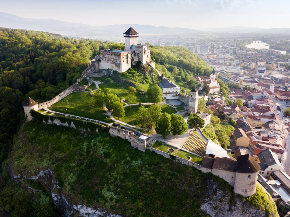 Beckov Castle rising on its sheer volcanic cliff above the Váh River valley — the centrepiece of the Piešťany Beckov Trenčín Čičmany day tour