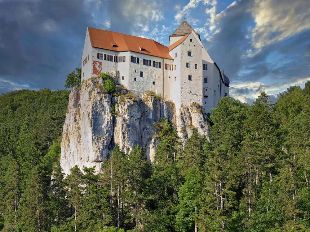 Burg Prunn rising from a vertical limestone crag above the Altmühl River in Bavaria — one of Germany's best-preserved medieval castles on the Altmühltal circuit from Regensburg
