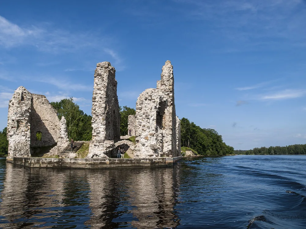 Koknese Castle ruins at the confluence of the Daugava and Pērse rivers in Latvia, medieval walls rising above the river confluence