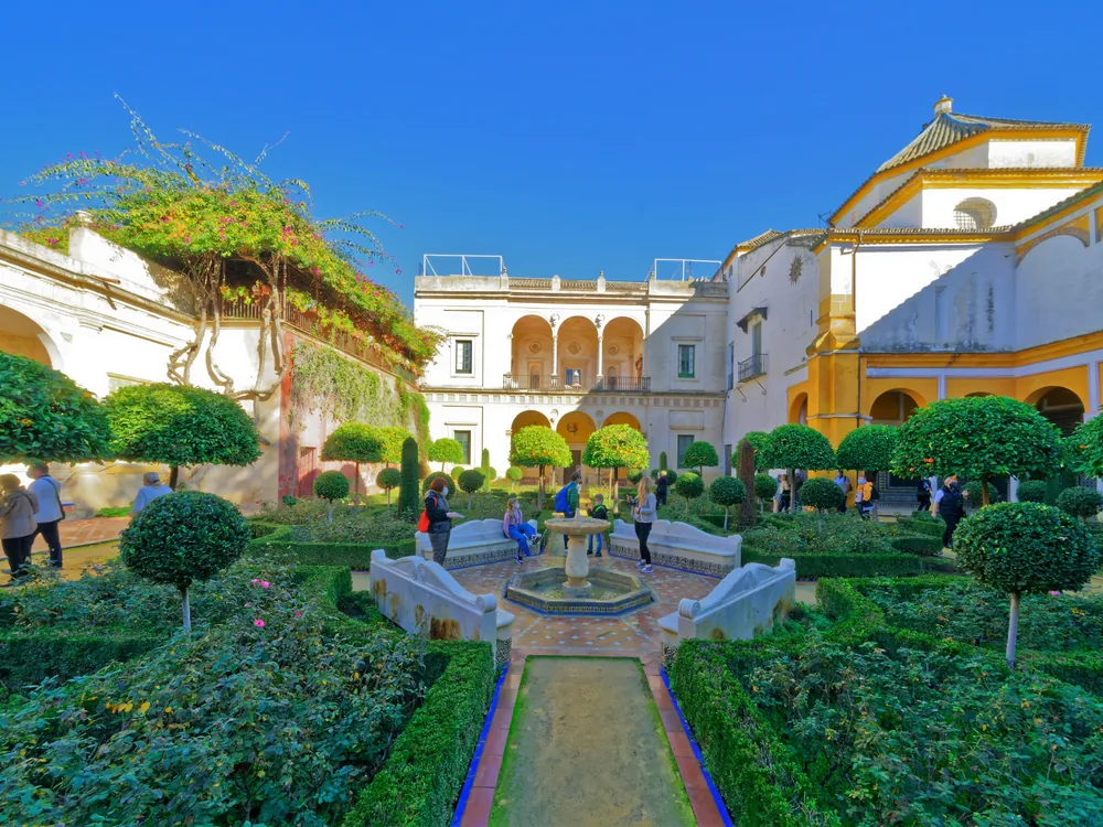 The Mudéjar-Renaissance courtyard of Casa de Pilatos in Seville, with azulejo tilework and classical statuary